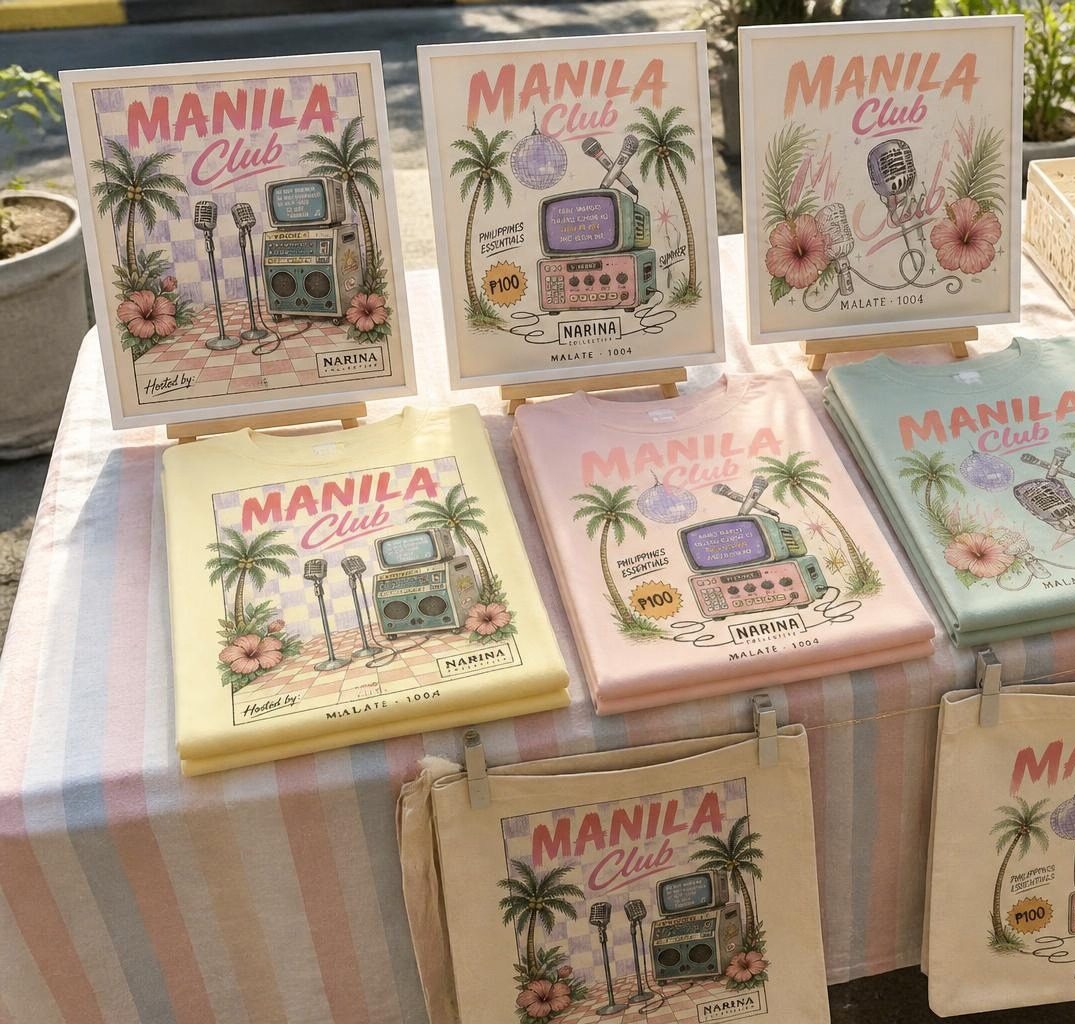 A market table laid out with pastel tees, totes and prints