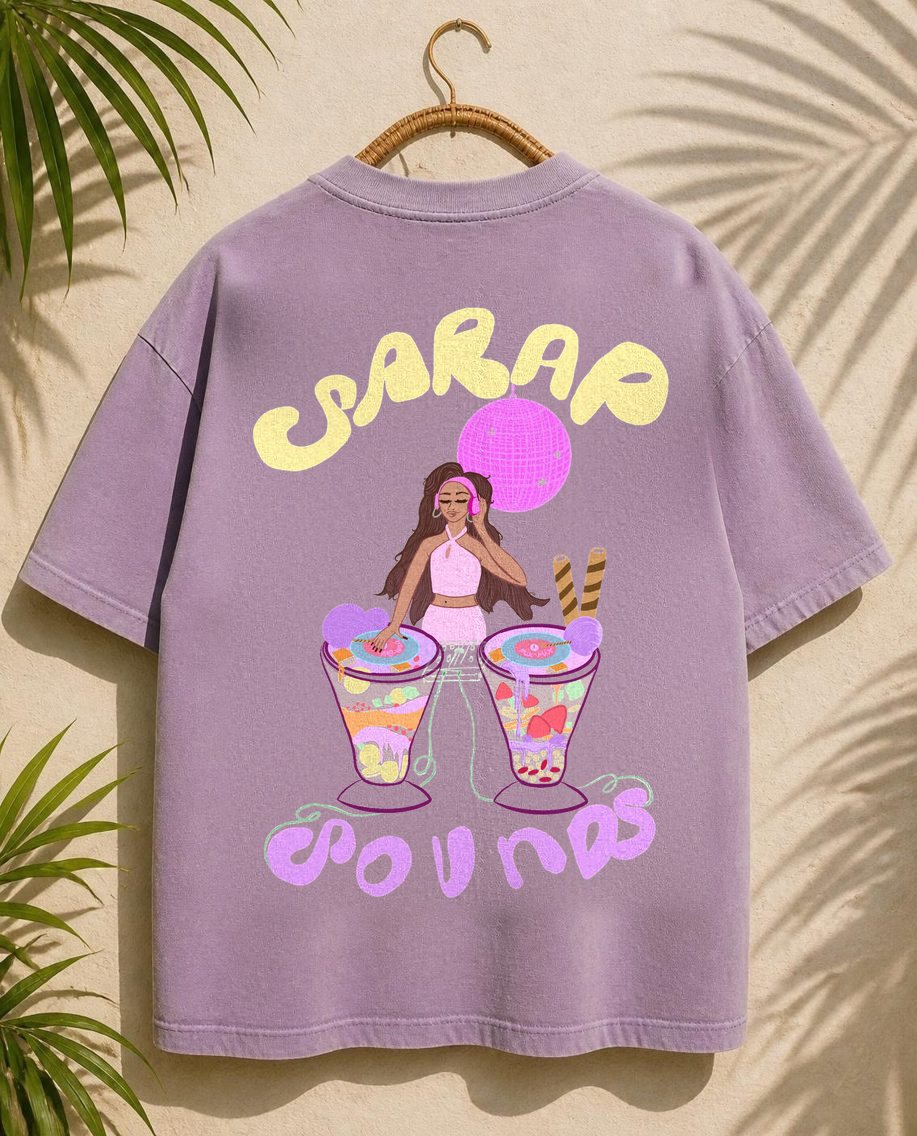 The back of a narina lilac boxy tee on a rattan hanger with the Sarap Sounds print